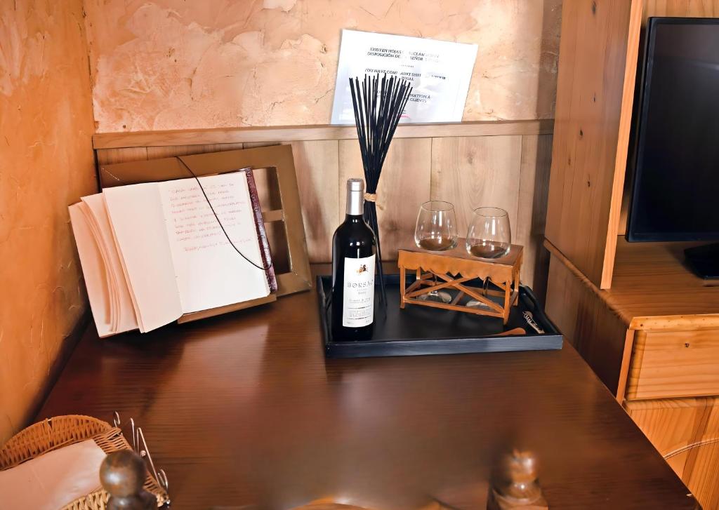 a bottle of wine and two glasses on a table at Casa Vaélico in Arenas de San Pedro