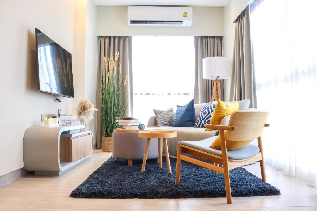 a living room with a couch and a table at Lakeside Residences by NLA in Bang Tao Beach