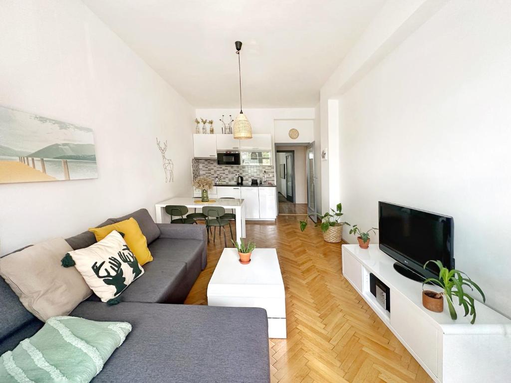 a living room with a couch and a tv at Bright and central suite with a balcony in Brno