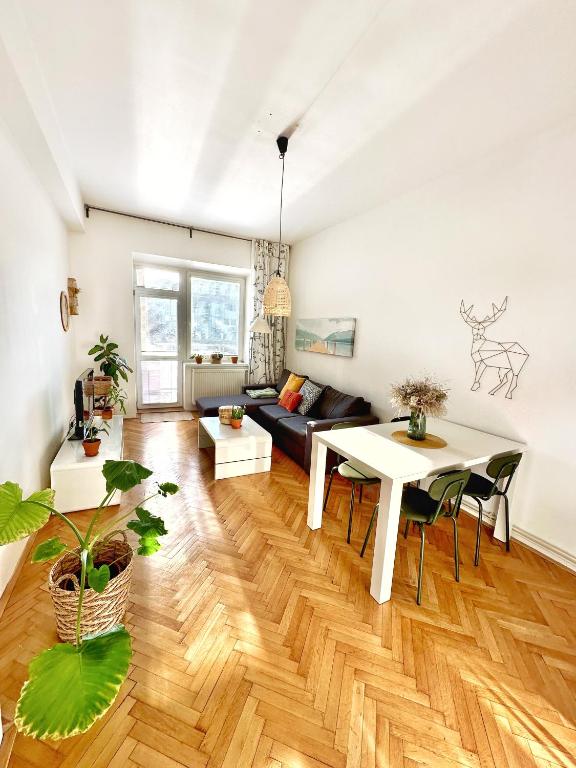 uma sala de estar com uma mesa e um sofá em Bright and central suite with a balcony em Brno