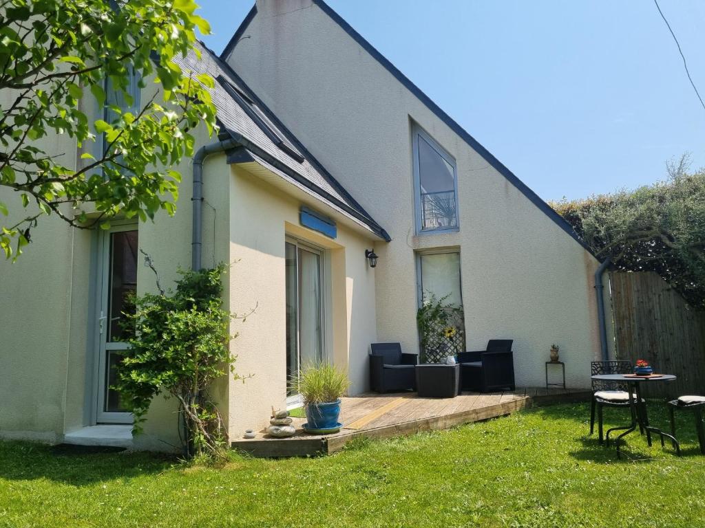 een wit huis met een houten terras in de tuin bij Roscoff Santec Maison Mer Bretagne in Santec