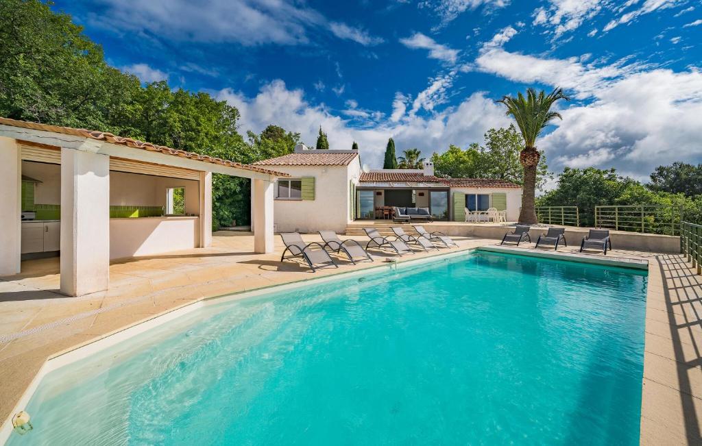 a swimming pool with chairs and a house at House With Pool Panoramic View in Saint-Cézaire-sur-Siagne