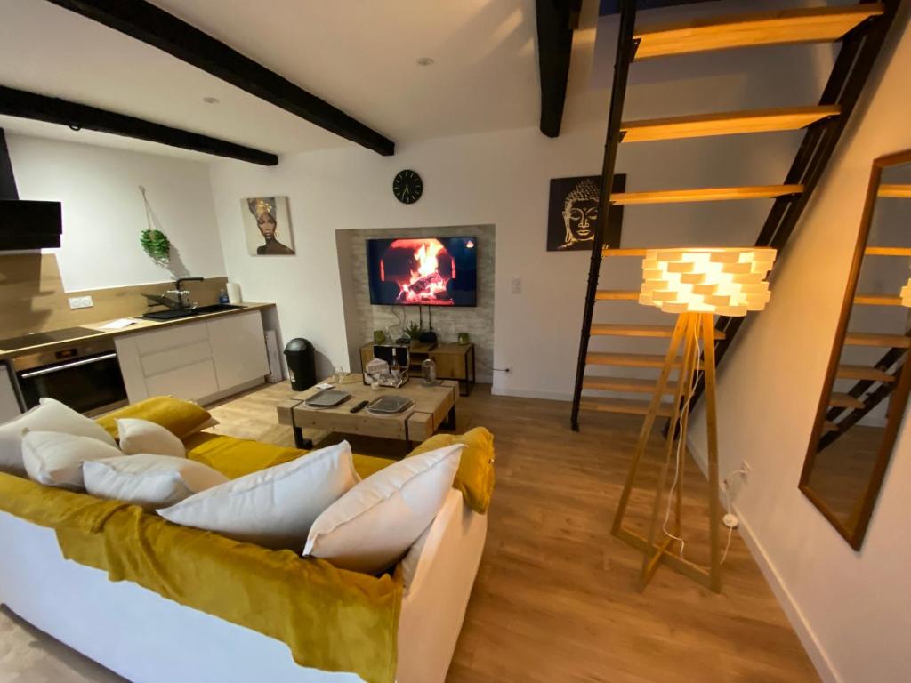 un salon avec un canapé et une télévision dans l'établissement La Grange Du Bien-être, à Liausson