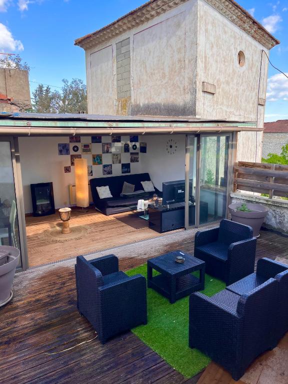- un salon avec des canapés et des chaises sur une terrasse dans l'établissement Appartement Alès, à Alès