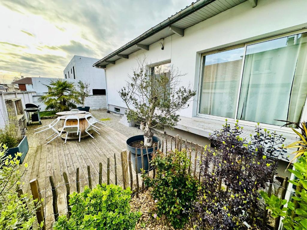 a backyard with a table and a fence at Belle maison avec jardin expose plein sud proche centre ville in Caen