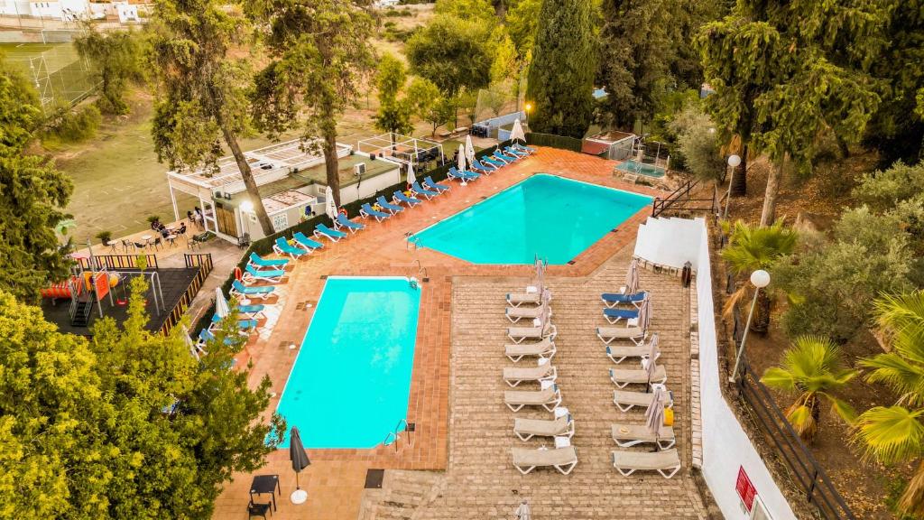 einen Blick über einen Pool mit Liegestühlen in der Unterkunft Hotel Finca Los Abetos in Córdoba