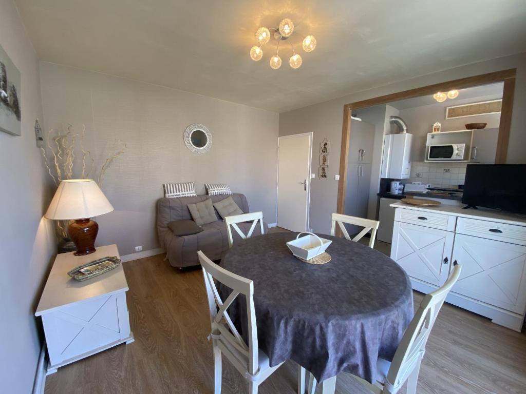 une cuisine et un salon avec une table et un canapé dans l'établissement Appartement Quartier Arago - Clocher St Pierre - 500m de la plage, à Les Sables-dʼOlonne
