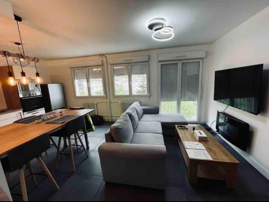 un salon avec un canapé et une table dans l'établissement L'Escale, à Clermont-Ferrand