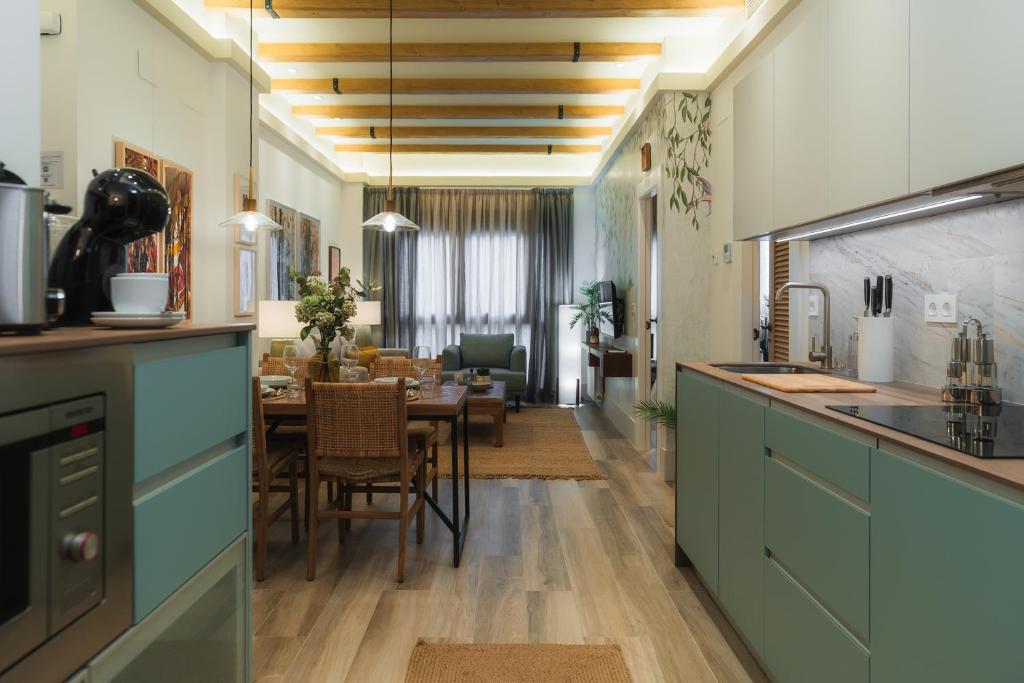 una cucina con armadi blu e una sala da pranzo di TuAnfitrion Constitución - Free parking a Granada