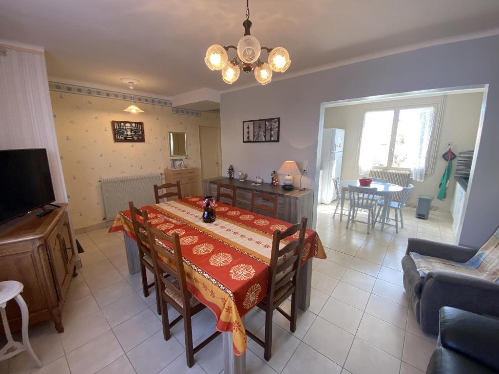 une salle à manger avec une table et un salon dans l'établissement Maison familiale agréable proche plage et remblai - GARAGE, à Les Sables-dʼOlonne