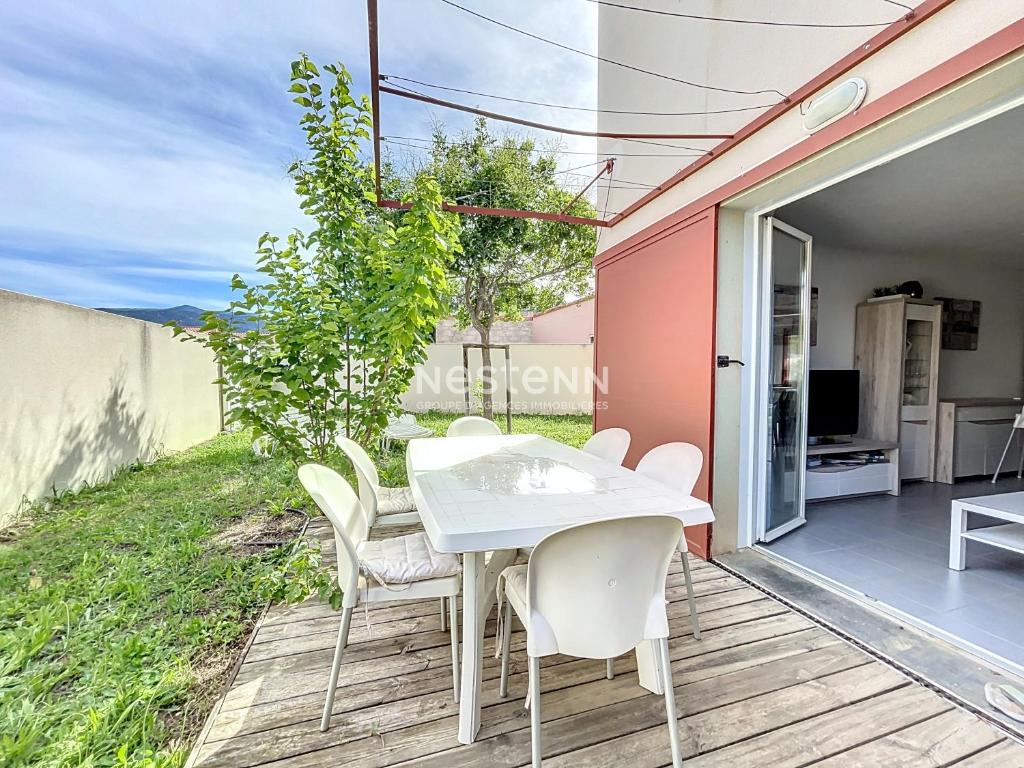 une table et des chaises blanches sur une terrasse en bois dans l'établissement 2949-Villa 3 chambres, 6 couchages, piscine, à Argelès-sur-Mer