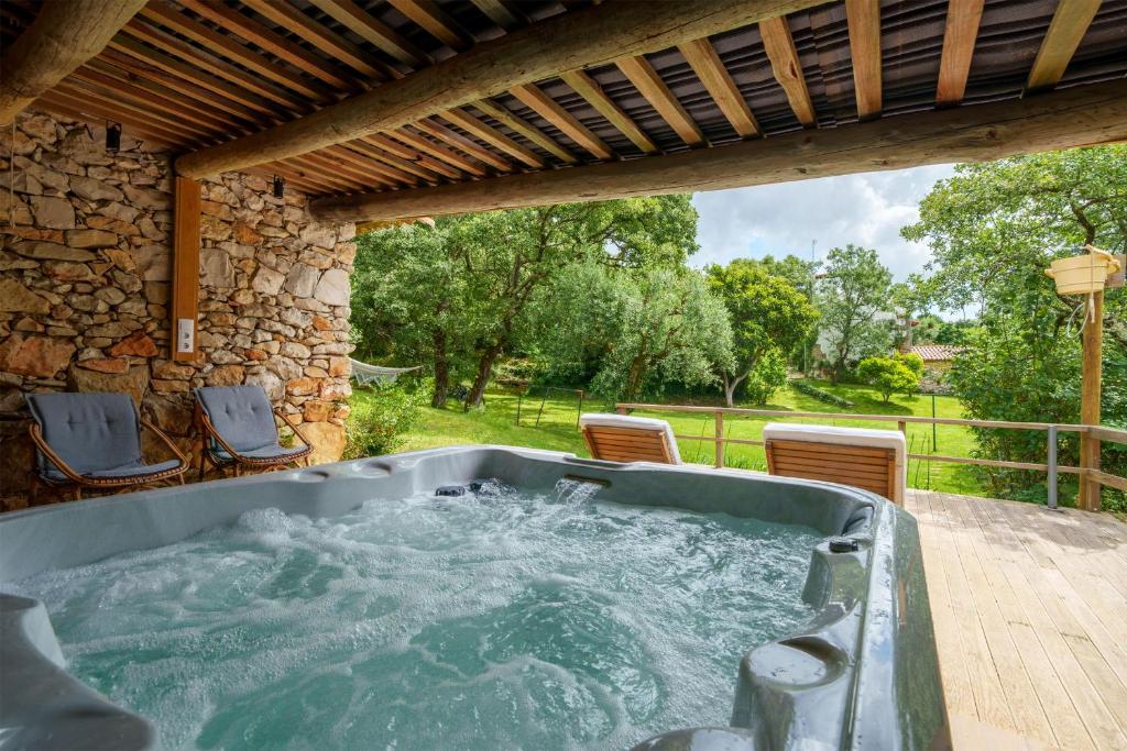 un jacuzzi en un patio con sillas en Casa do Vale do Papo, en Pombal