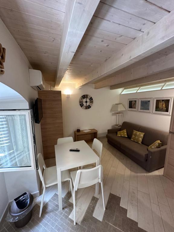 ein Wohnzimmer mit einem Tisch und einem Sofa in der Unterkunft More Apartments il Ferrarese2 in Bari