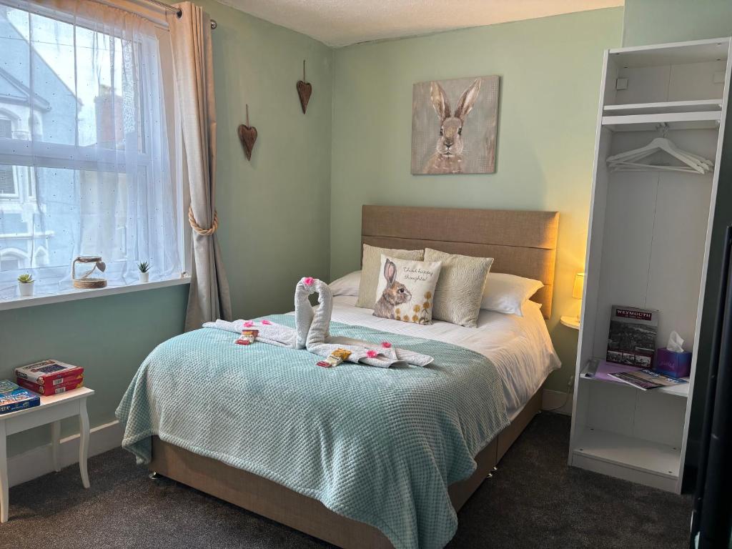 Un dormitorio con una cama con dos muñecas. en Calm sea guesthouse en Weymouth