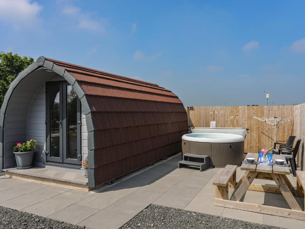 a gazebo with a bath tub in a yard at Parys Pod in Bodewryd