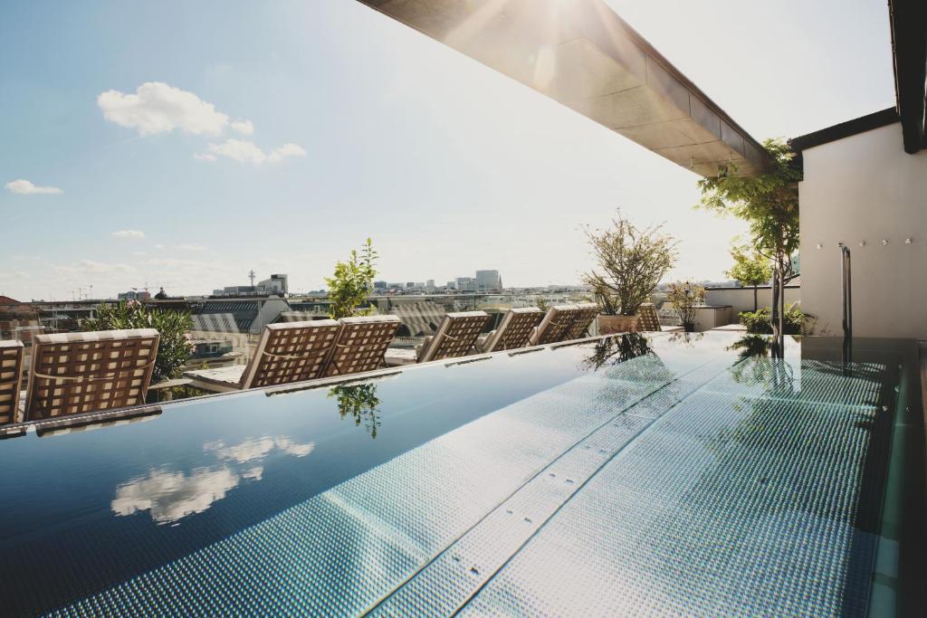 a swimming pool on the roof of a building at Grand Ferdinand Vienna – Your Hotel In The City Center in Vienna