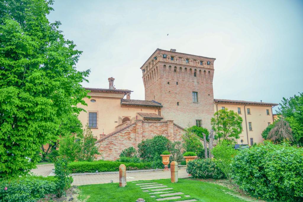 ein großes Gebäude mit einem Turm darüber in der Unterkunft Hotel La Tavola Rotonda in Cortemaggiore