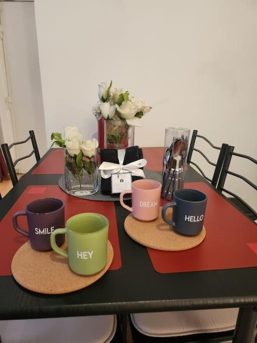 une table avec trois tasses à café sur des assiettes dessus dans l'établissement Logement entier 2p, à Paris
