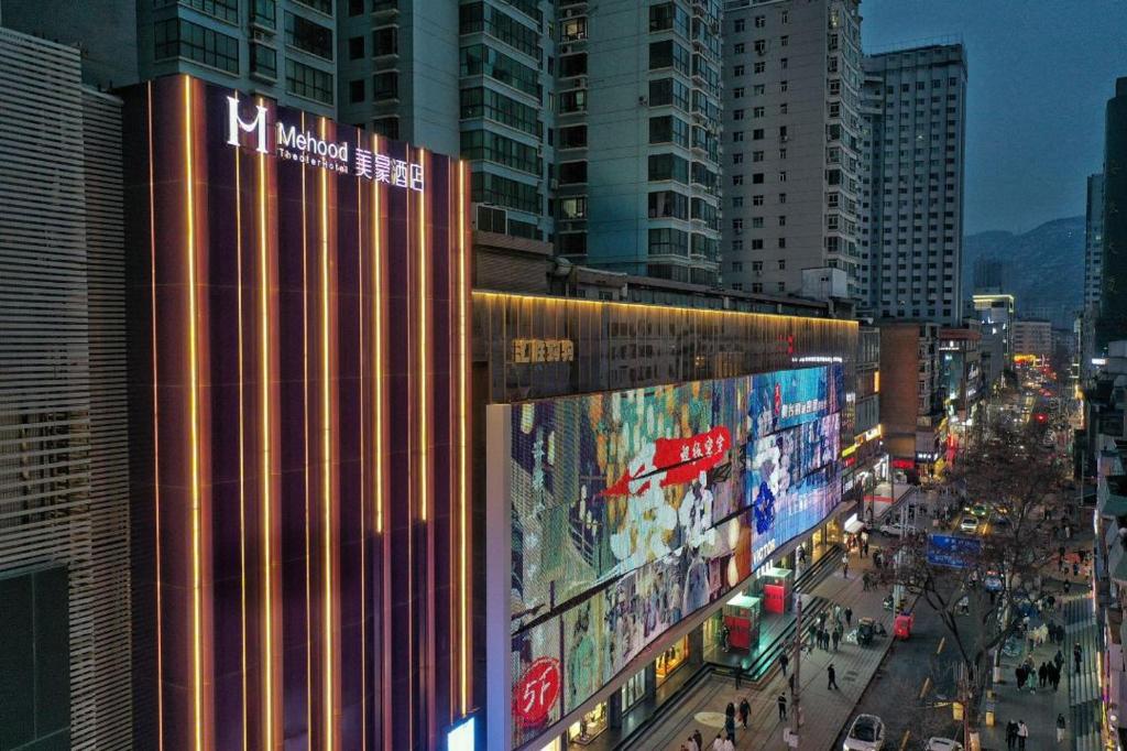 a city with tall buildings and a street with people at Mehood Theater Hotel, Lanzhou Xiguan Metro Station Zhangye Road Pedestrian Street in Lanzhou