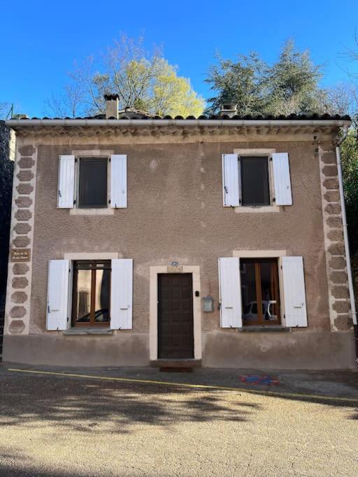 un bâtiment avec trois fenêtres et une porte dans l'établissement Maison cévenole typique et son jardin suspendu, à Lasalle