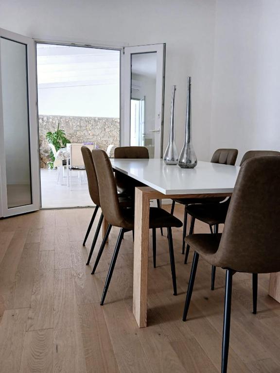 a dining room with a white table and chairs at Casa Mascia Pinna in Maracalagonis