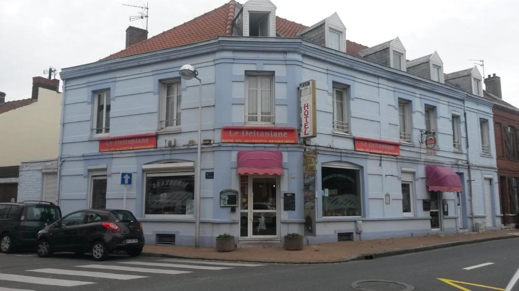 un edificio azul con un coche aparcado delante de él en Le Deltaplane, en Blériot-Plage