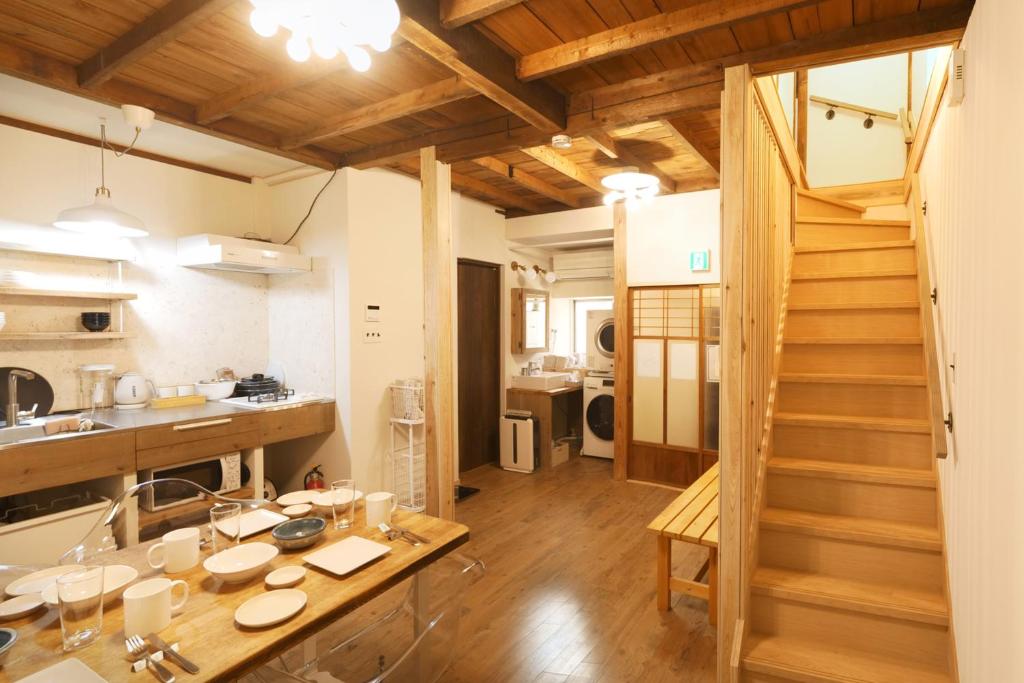 a kitchen with a table and a staircase in a room at 木庵 "Moku-an"Tiny house go to Kyoto Nara in 1 hour in Osaka