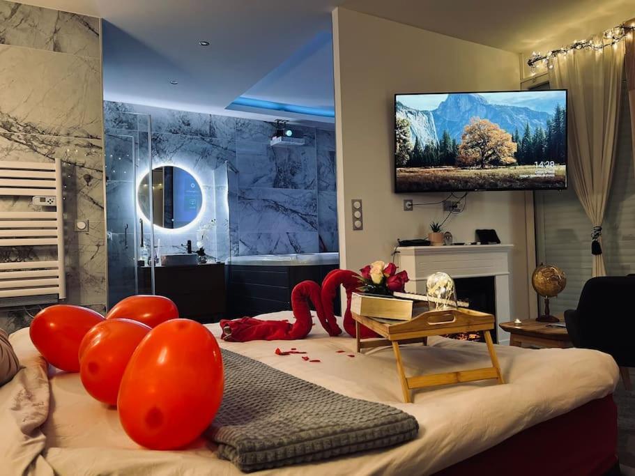 Cette chambre comprend un lit avec des ballons rouges. dans l'établissement L'Olympe, à Chamalières