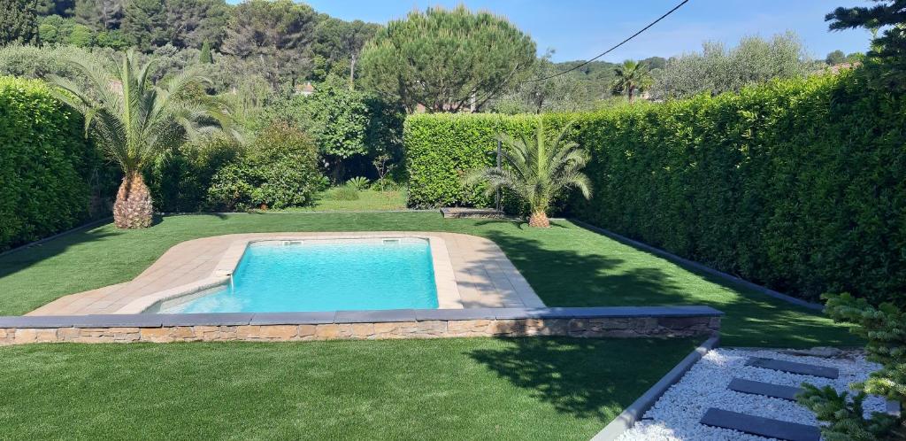 - une piscine dans une cour avec une haie dans l'établissement Meublé 2P 40 m2 dans villa avec piscine à Vallauris, 4 km de la mer, à Vallauris