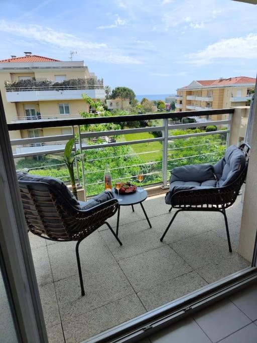 un balcon avec deux chaises et une table sur un balcon dans l'établissement Bright & calm sea-view apartment, à Antibes