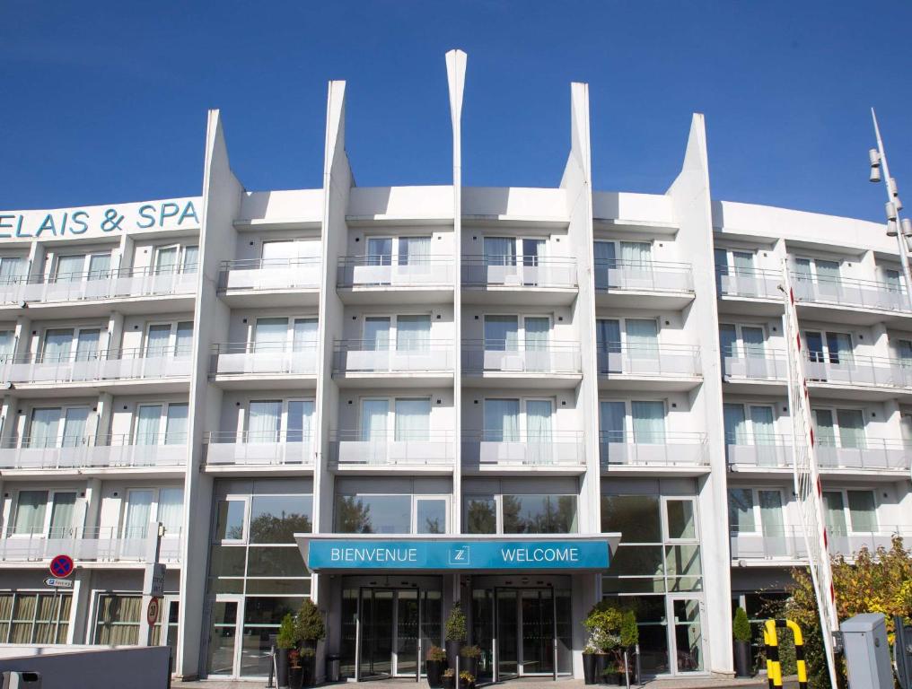 - un grand bâtiment blanc avec un panneau devant dans l'établissement Clarion Paris CDG Airport, à Roissy-en-France