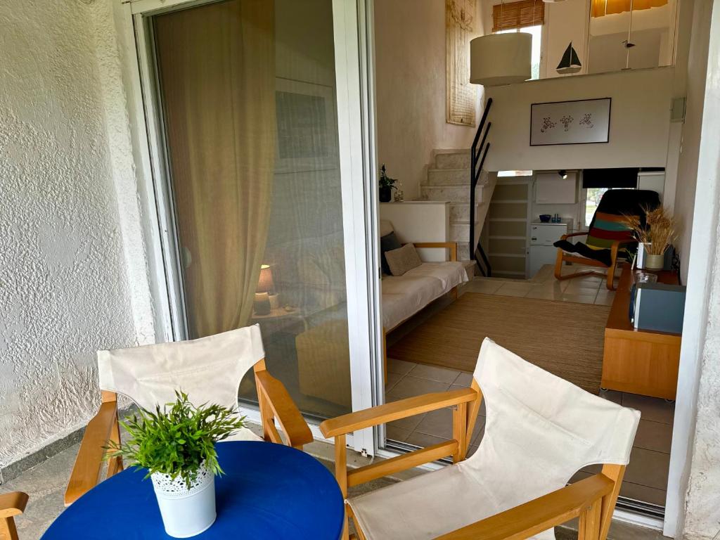 una camera con tavolo e sedie e un soggiorno di Sunset Hill Escape a Skála Foúrkas