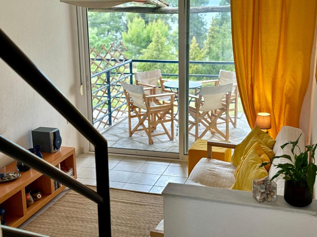 un soggiorno con balcone arredato con tavolo e sedie. di Sunset Hill Escape a Skála Foúrkas