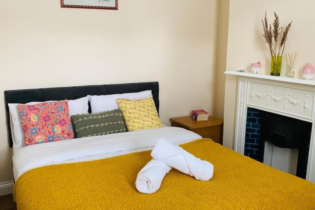 a white towel laying on a bed with a fireplace at Families and contractors Free off road parking in Huntingdon