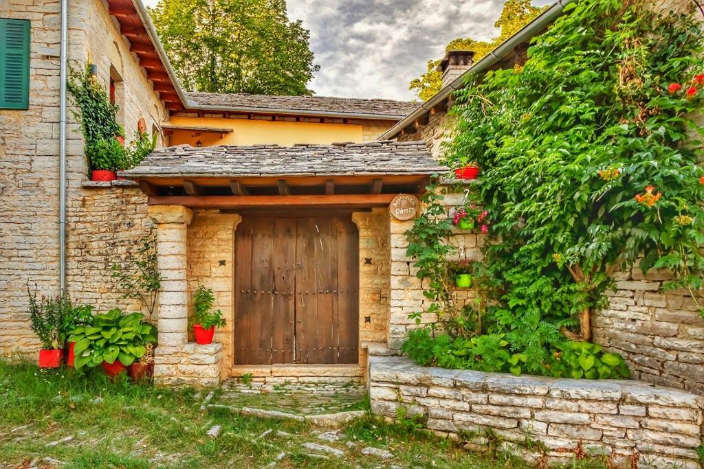 Casa de piedra con puerta de madera en un patio en Archontiko Rapti Stone Traditional House en Monodendri
