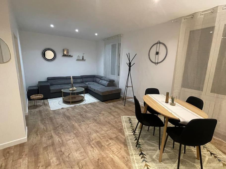 un salon avec un canapé, une table et des chaises dans l'établissement L'Epicentre, à Clermont-Ferrand