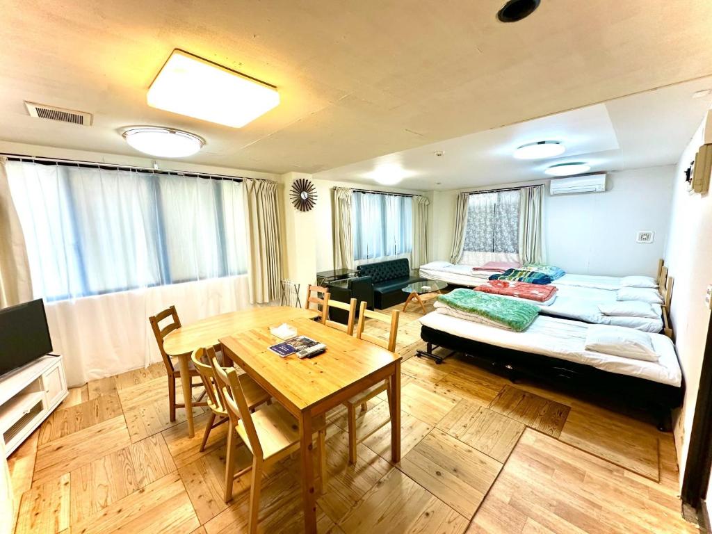 ein Wohnzimmer mit einem Tisch und einem Sofa in der Unterkunft Shibasaki House 1F - Vacation STAY 13848 in Kusatsu