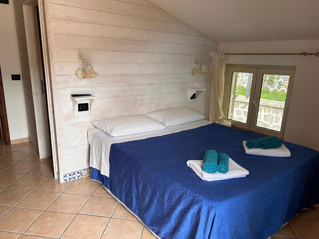 um quarto com uma cama azul com duas almofadas em Villa Alessandra em Maratea