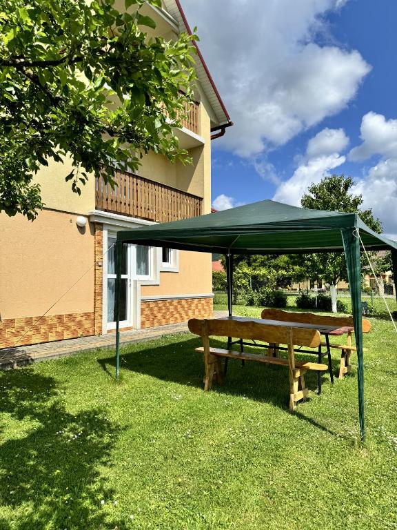 a picnic table with a green canopy in the grass at Kwatera Studio Hoczew in Hoczew