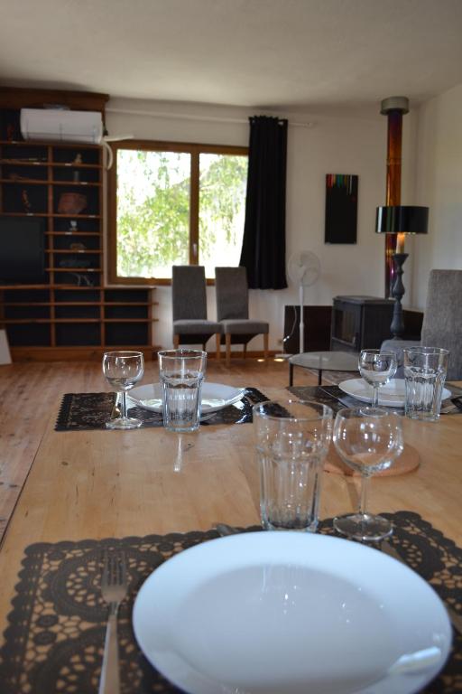 une table avec une plaque blanche et des verres sur celle-ci dans l'établissement Convivial gîte 6-10-13 pers avec jacuzzi Cévennes entre Anduze et Alès, à Carnoulès