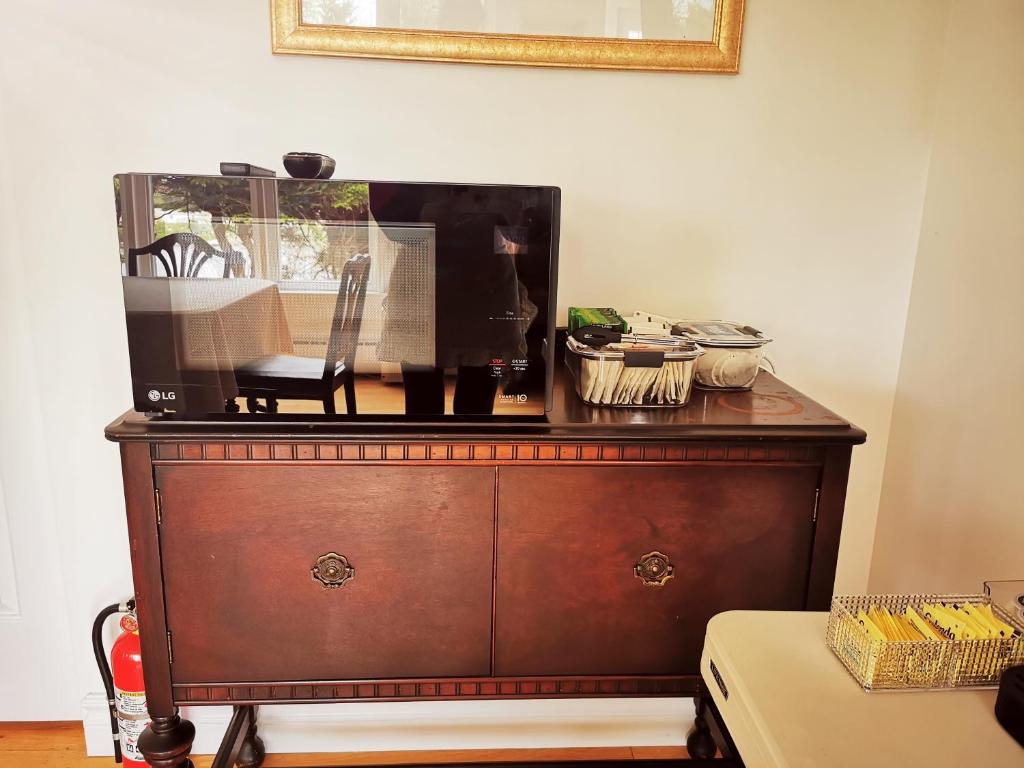 a dresser with a television on top of it at 181 Oceanside Inn in Peggy's Cove
