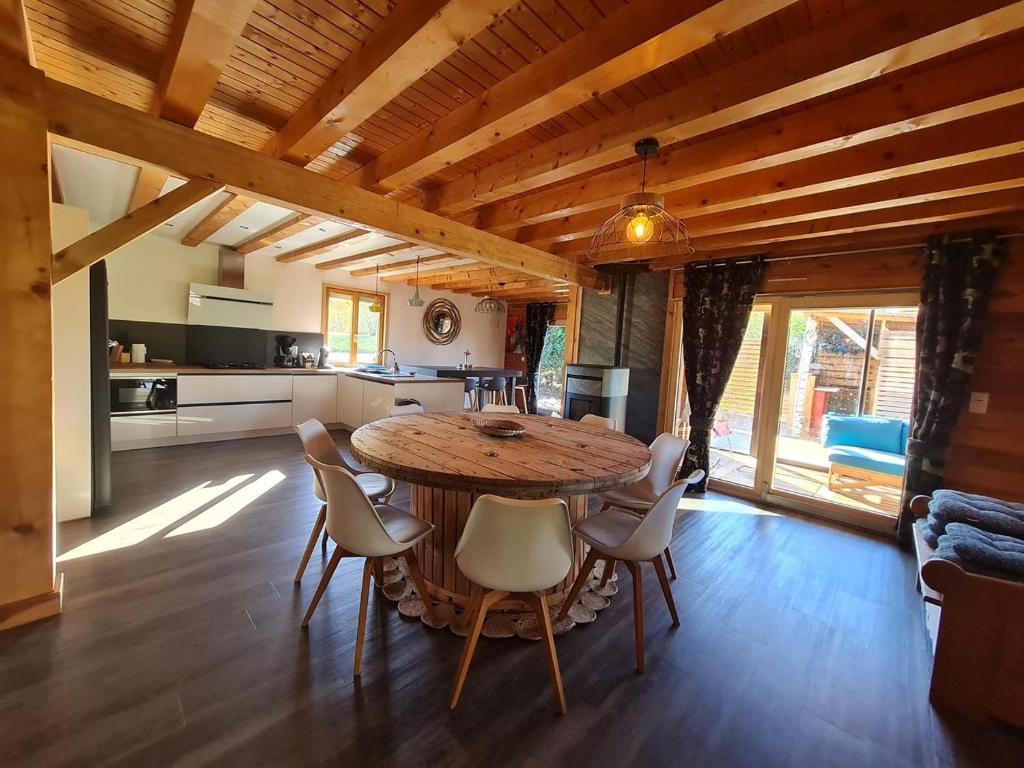 eine Küche und ein Esszimmer mit einem Holztisch und Stühlen in der Unterkunft Chalet La Dame du lac cocooning in Gérardmer