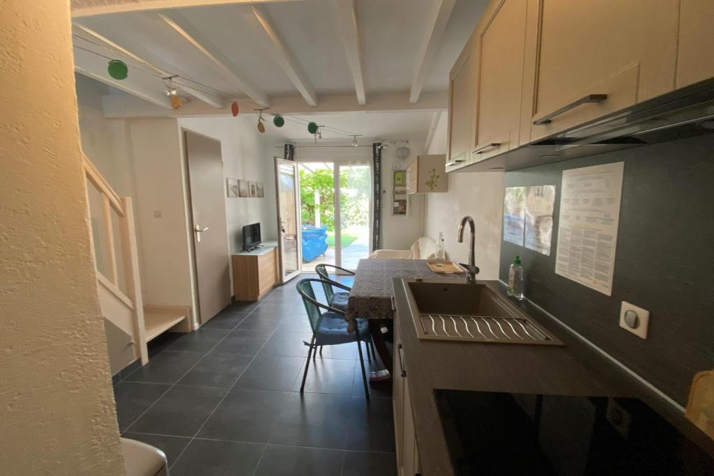 une cuisine avec un évier et une table avec des chaises dans l'établissement A stone's throw from the sea!, à Frontignan