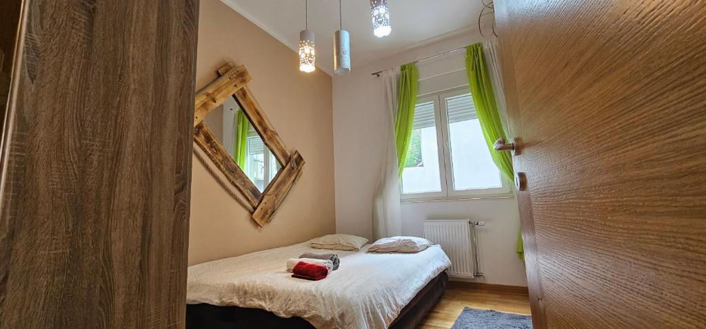 małą sypialnię z łóżkiem i lustrem w obiekcie Apartman Kalina w Nowym Sadzie