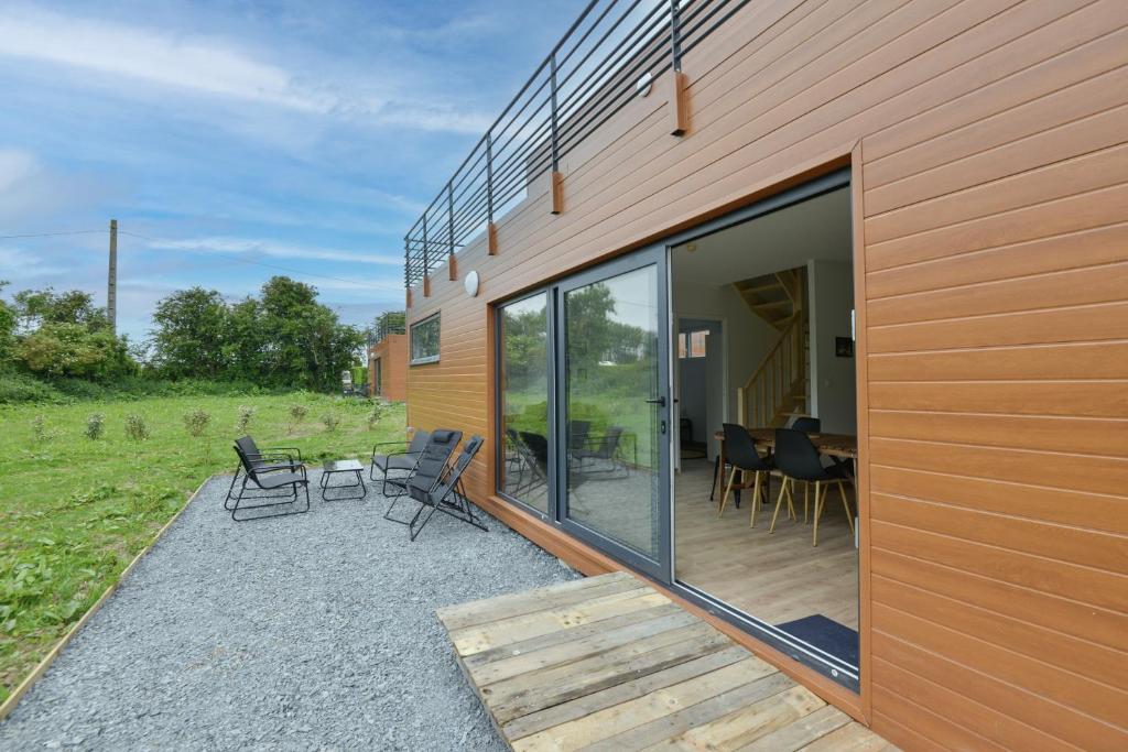 taras z krzesłami i stołem obok budynku w obiekcie Le Normandy - Sauna - A moins de 2 km de la plage w mieście Sainte-Honorine-des-Pertes