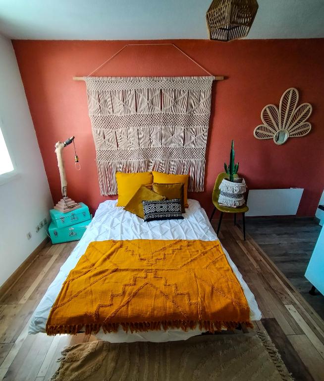 une chambre avec un lit avec un mur orange dans l'établissement Le fringant, à Avignon