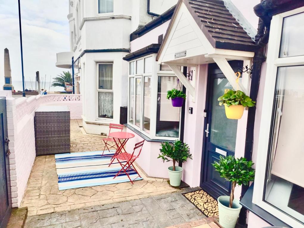 a porch with a bench and potted plants at Bexhill Stunning 2 bedroom Sea Front Bungalow in Bexhill
