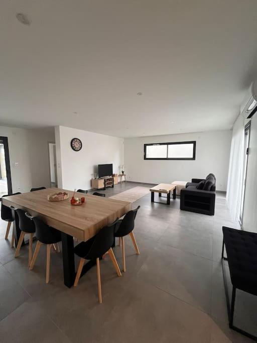 - un salon avec une grande table et des chaises en bois dans l'établissement Villa à Cébazat, à Cébazat