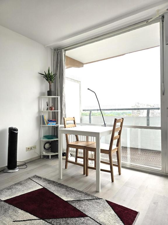 a white dining room with a white table and chairs at City View in Offenbach