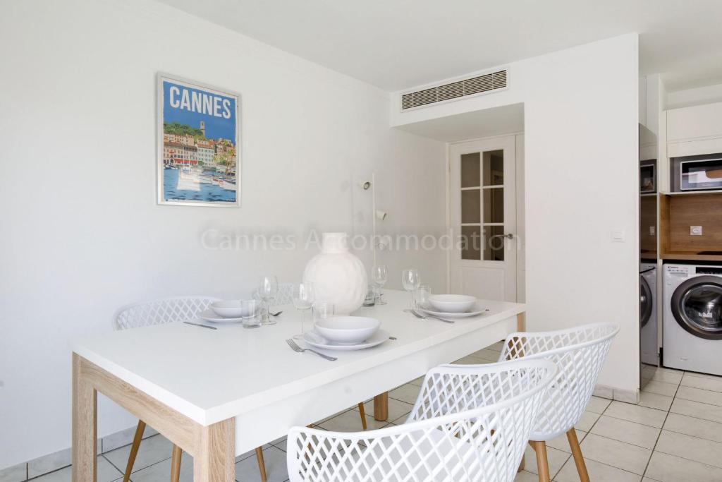 une salle à manger blanche avec une table et des chaises blanches dans l'établissement Palazzio RE, à Cannes